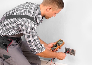 Man Testing Outlet With Multimeter